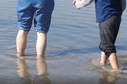 Mother and child paddling in the sea.