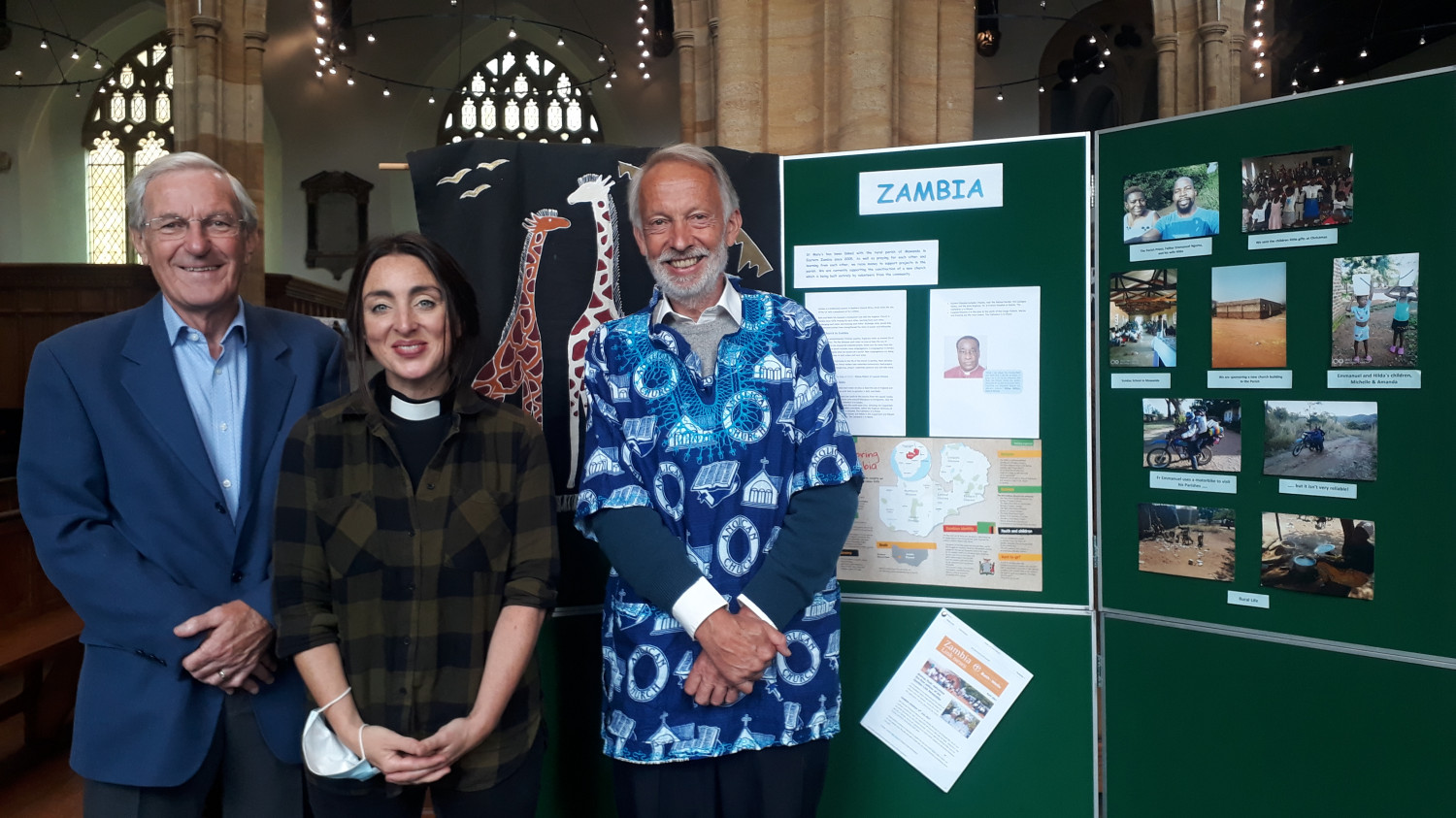 three people infront of a notice board