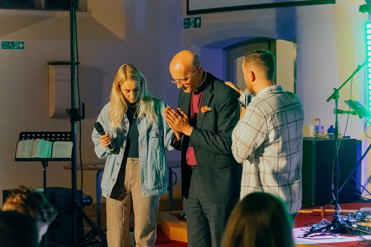 Bishop Michael prays with young people at Movement worship night